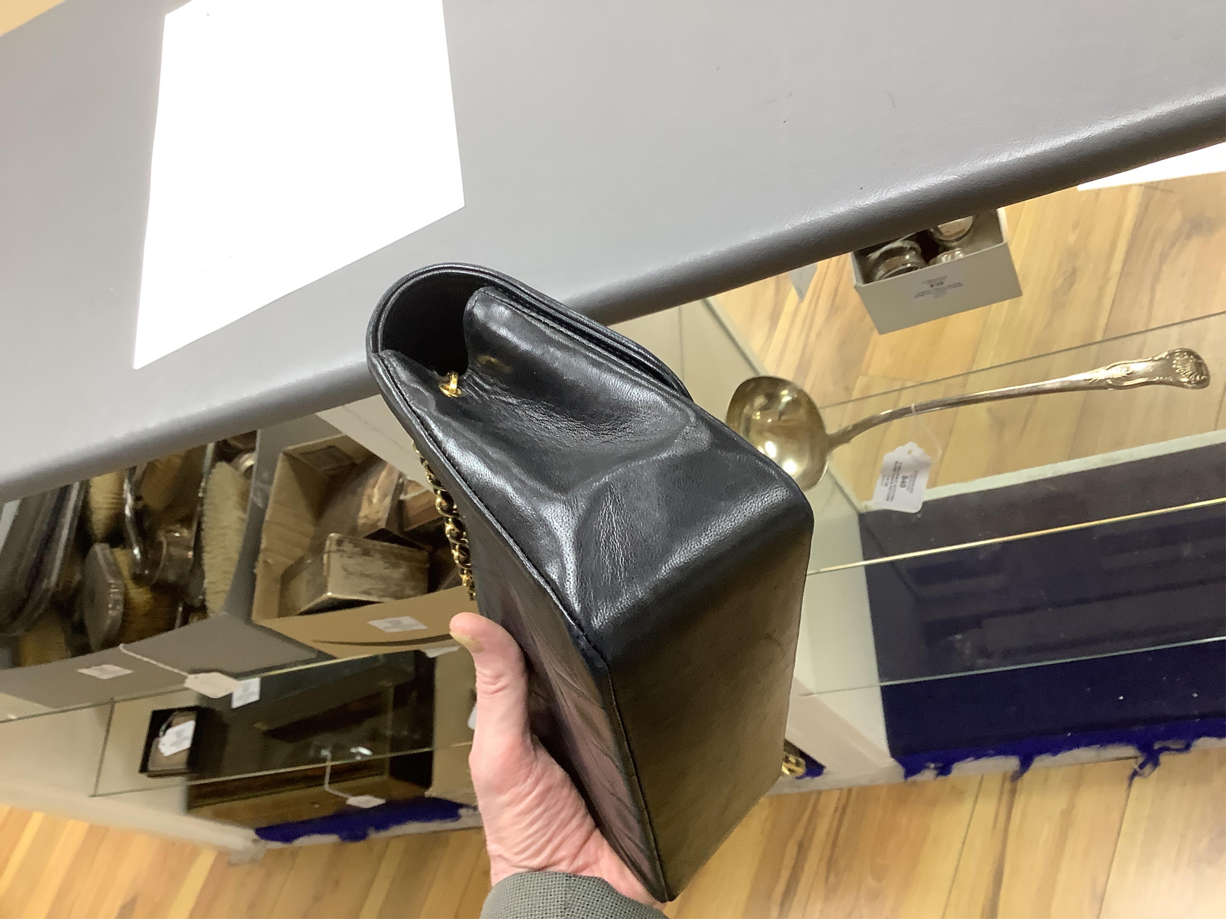 A late 1980’s Chanel black leather Diana shoulder bag with original dust cover and bag, Chanel authenticity card numbered 1944645, interior date code rubbed, 23cm wide, Provenance: Purchased by the vendor, 26 Old Bond St